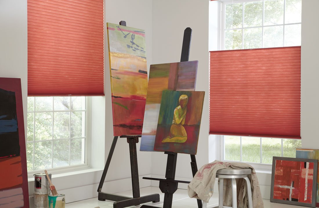 Close up shot of 2 Parasol® Top Down Bottom Up shades positioned at different heights with art on easels sitting in front