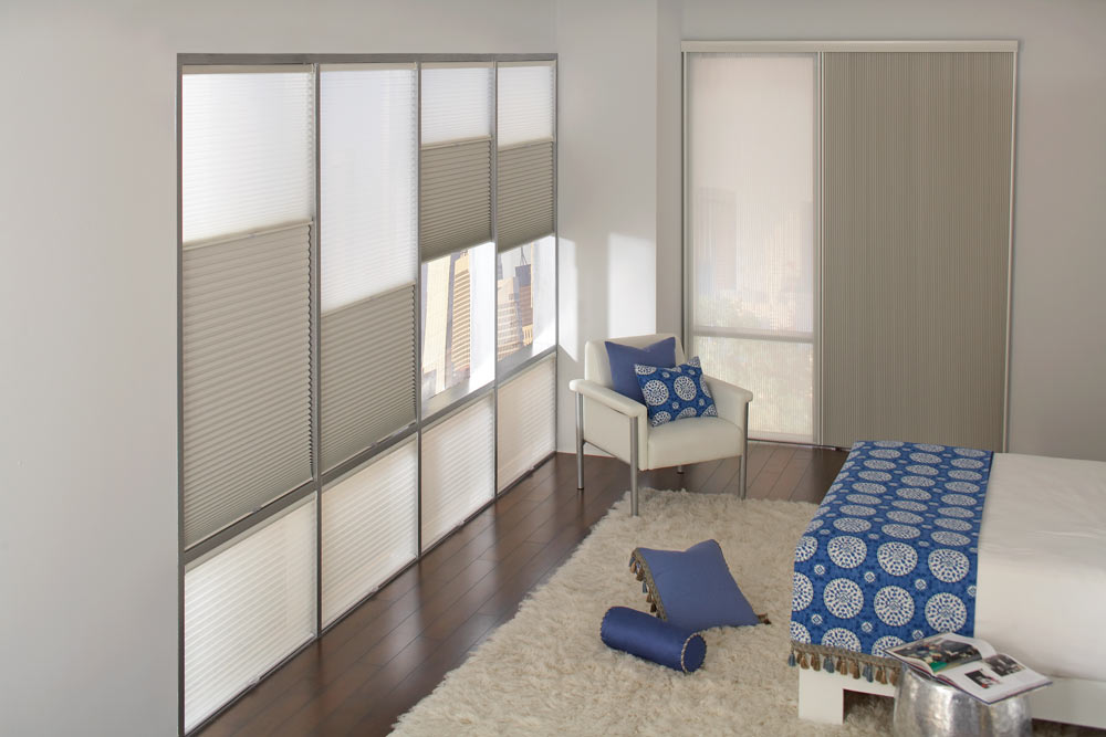 several large white Parasol® Cellular Shades & blue and white Interior Masterpieces® Custom Pillows and Bedding