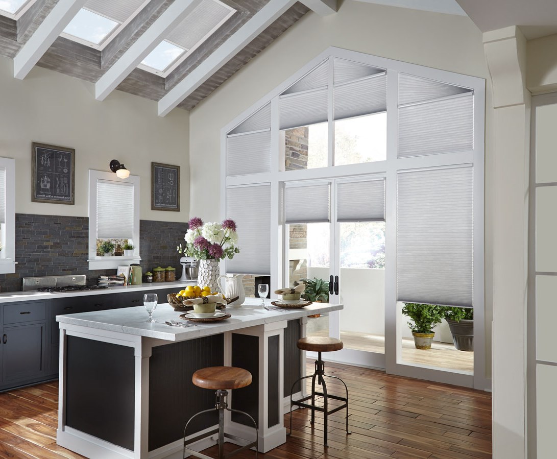 Several Parasol® Cellular shades in a large wall of windows that come up to a point that have Palladian Angled specialty shaped Cellular shades at the top along with Parasol® motorized shades in the skylights